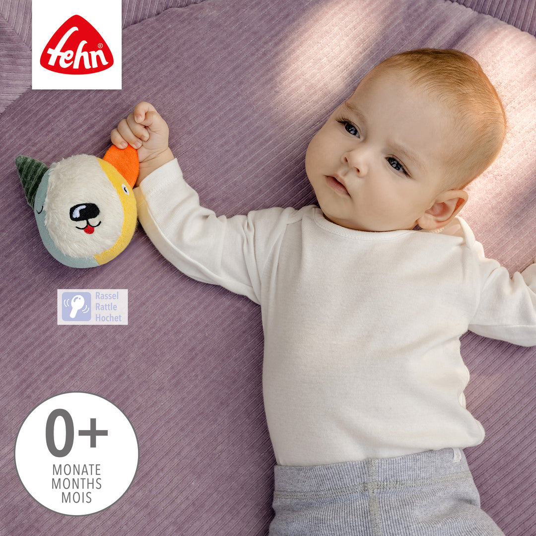 Baby hält Baby Stoffball Hund