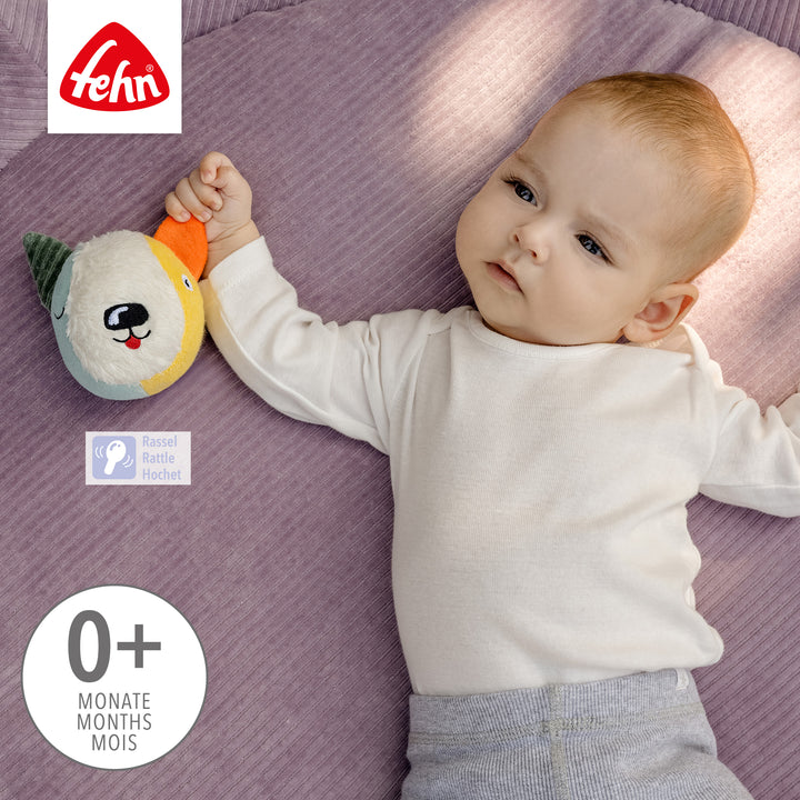 Baby hält Baby Stoffball Hund