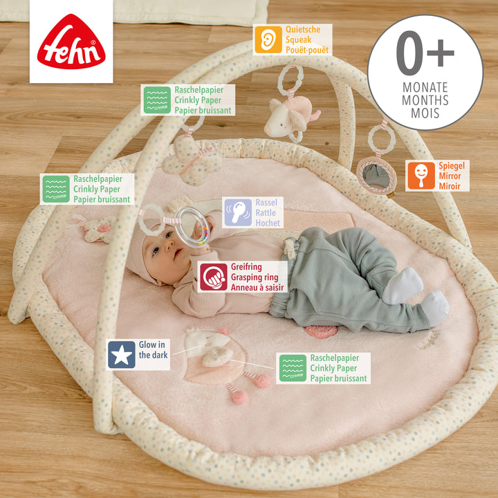 Baby liegt in Baby 3-D-Activity-Decke Vogel und greift nach Spielelement