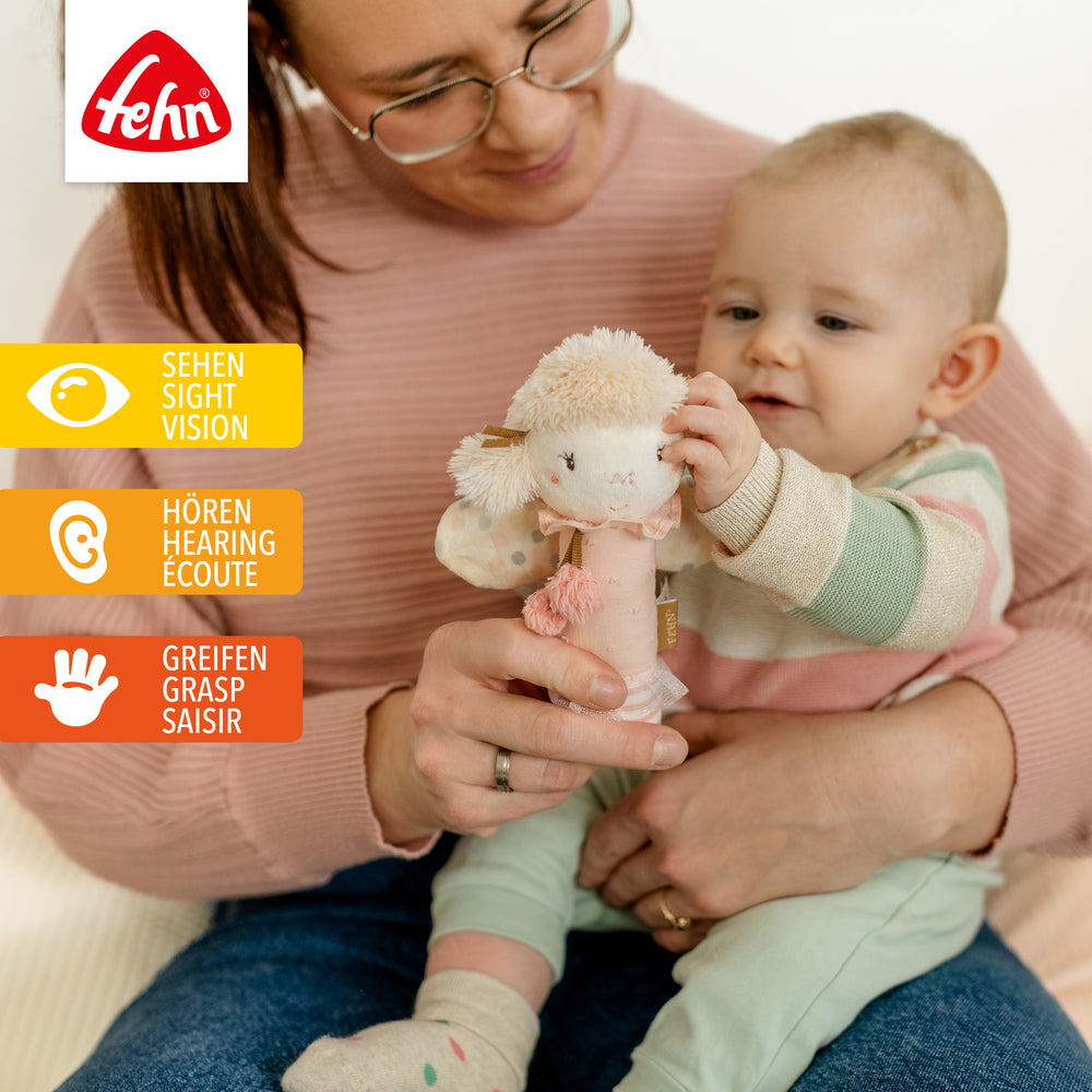 Baby spielt mit Plüsch-Stabgreifling Fee