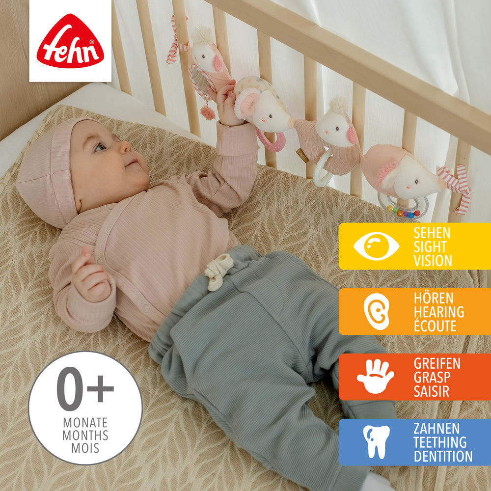 Baby greift nach Baby Kinderwagenkette feehnLAND aus weichem Plüsch