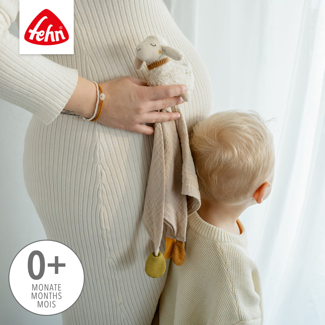 Mutter mit Kind hält Baby Schmusetuch Schaf