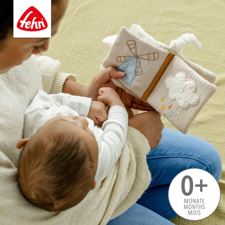 Baby blättert im Baby Stoffbuch Schaf mit Spielelementen