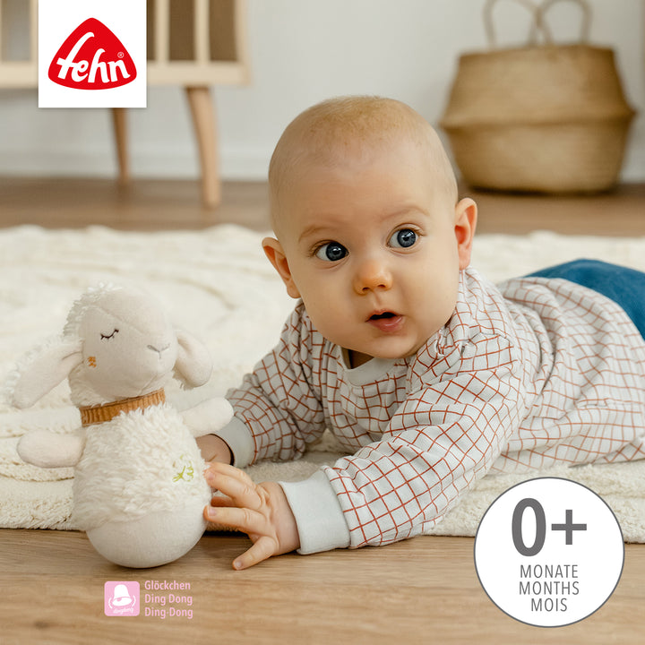 Baby spielt in Bauchlage mit Baby Mini-Stehauf Schaf