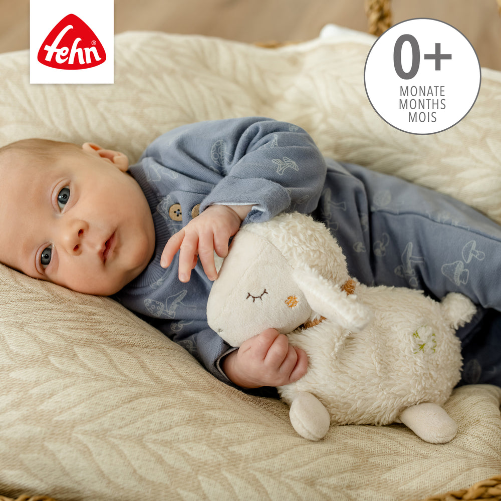 Baby kuschelt mit Baby Wärmetier Schaf aus weicher Baumwolle
