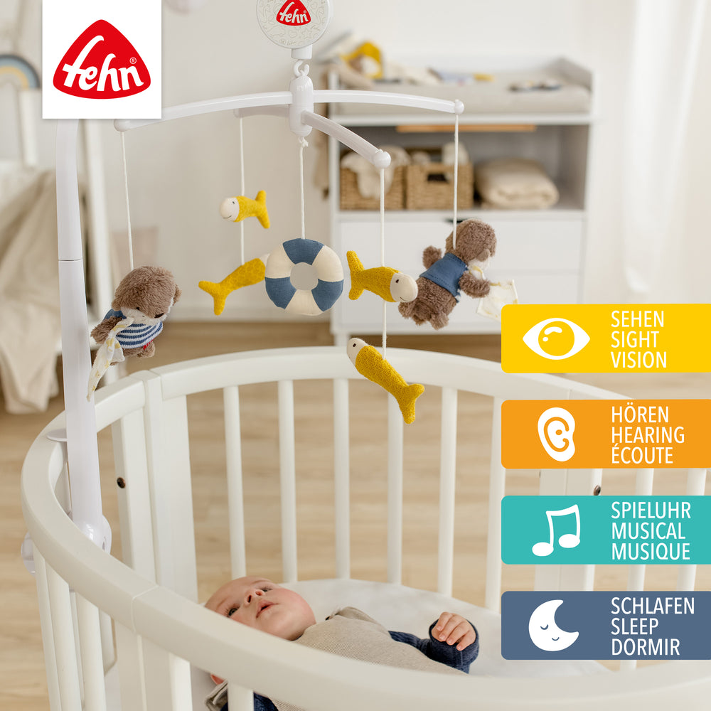 Baby liegt unter Baby Musik-Mobile Otter