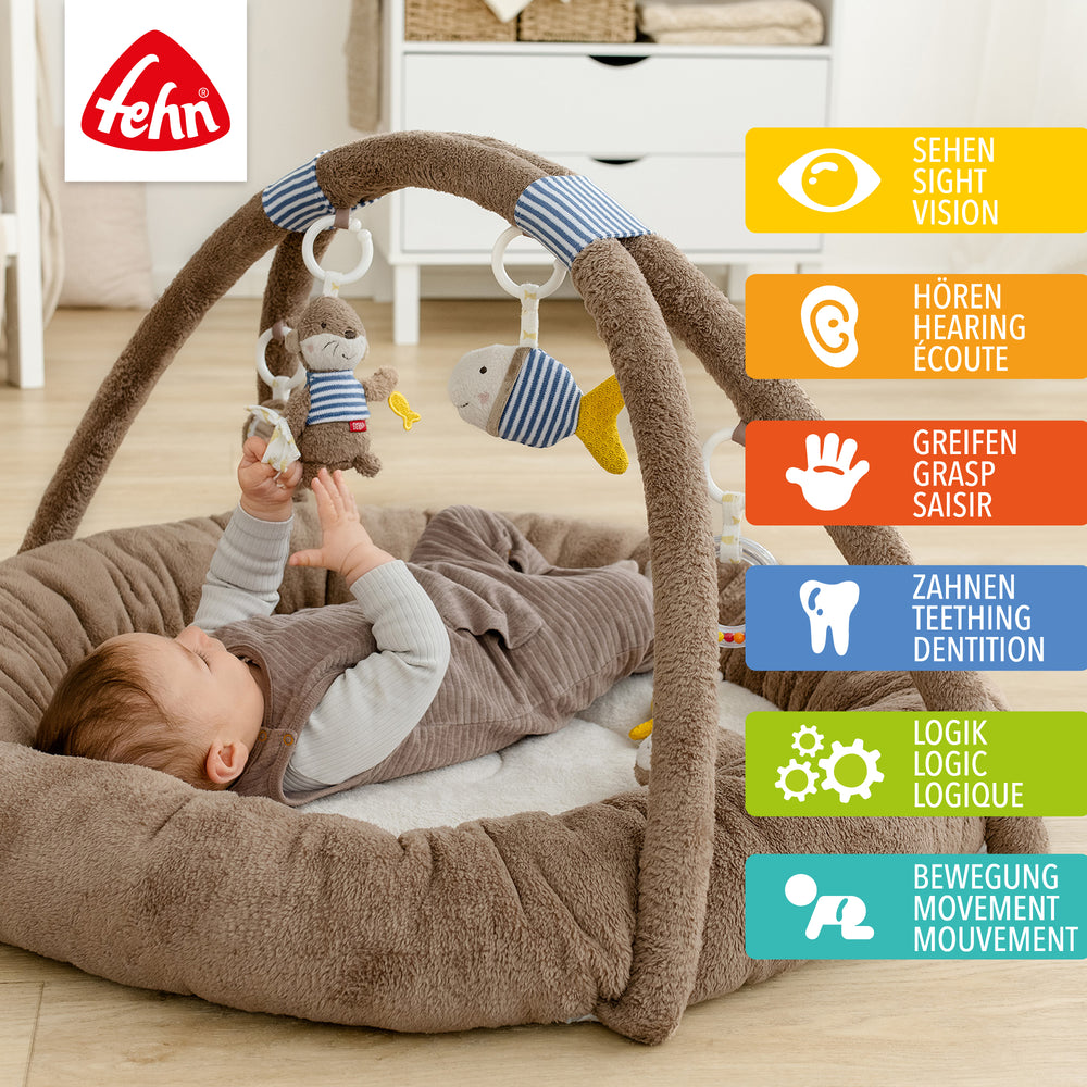 Baby liegt in Baby 3-D-Activity-Nest Otter und greift nach Spielelement