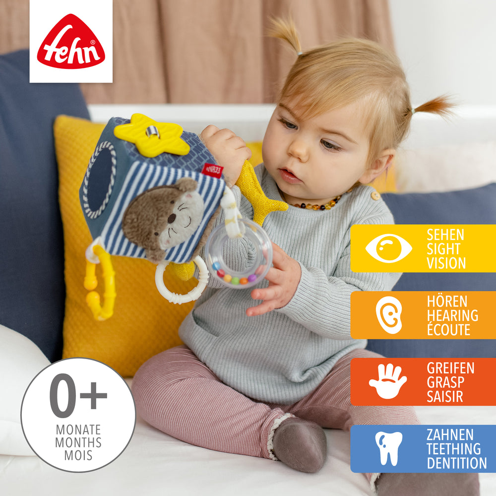 Baby spielt mit Baby Activity-Würfel Otter aus weichem Plüsch