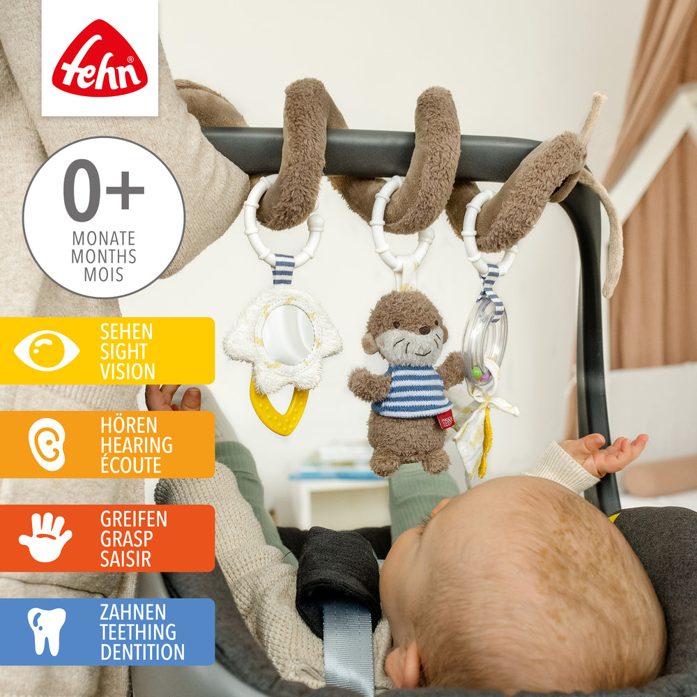Baby spielt mit Baby Activity-Spirale Otter aus weichem Plüsch