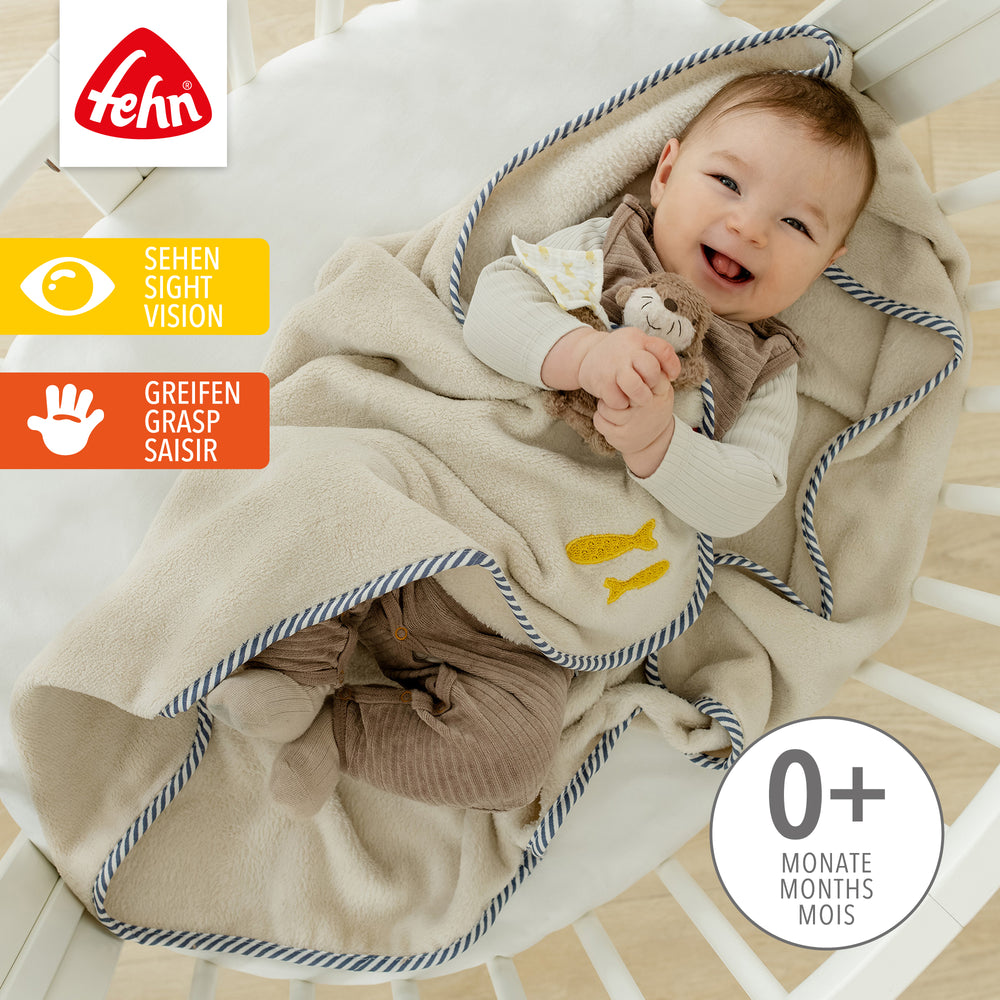 Baby liegt in Baby Kuscheldecke Otter