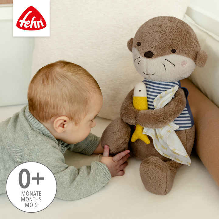 Baby spielt mit Baby Kuscheltier Otter XL aus weichem Plüsch
