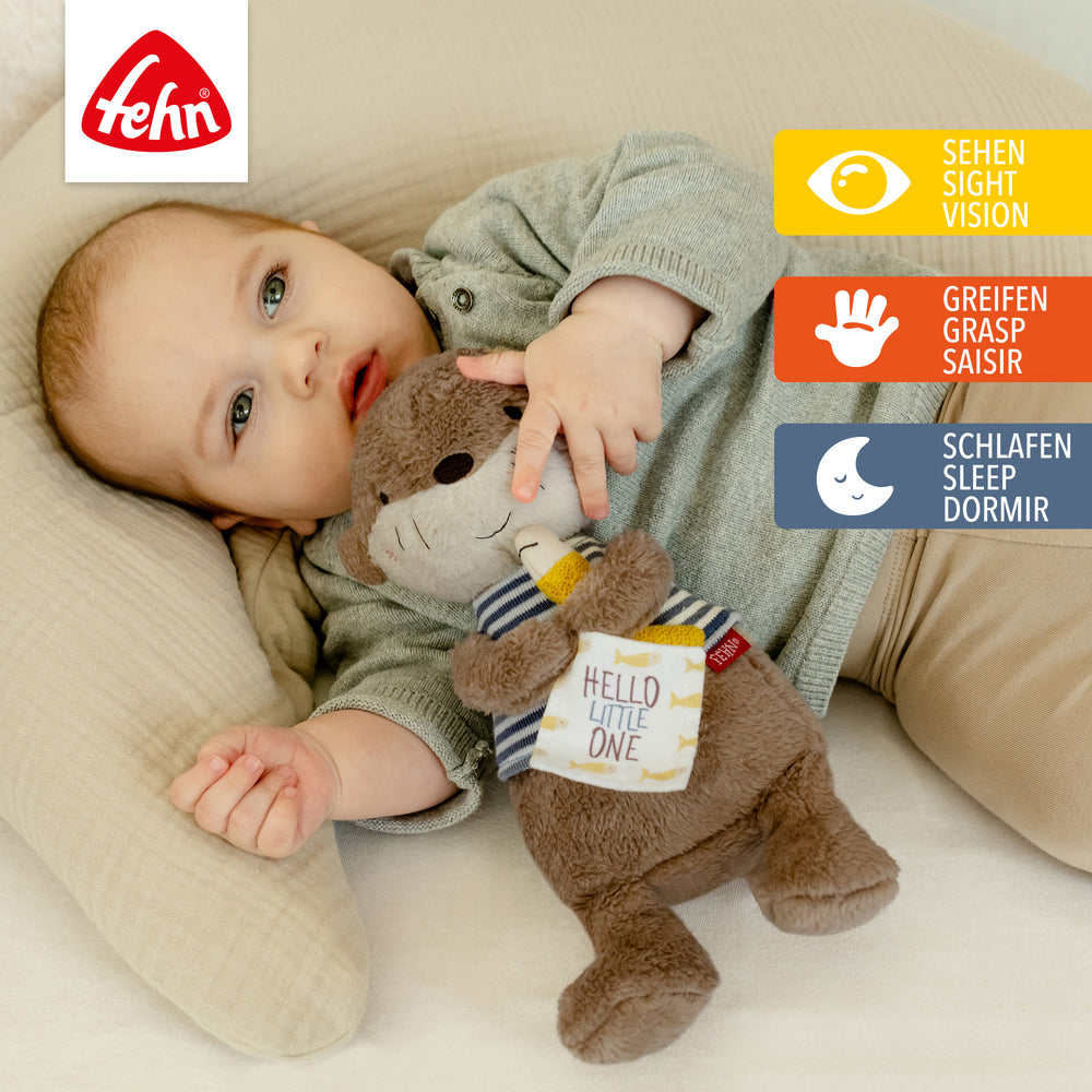 Baby spielt mit Baby Kuscheltier Otter