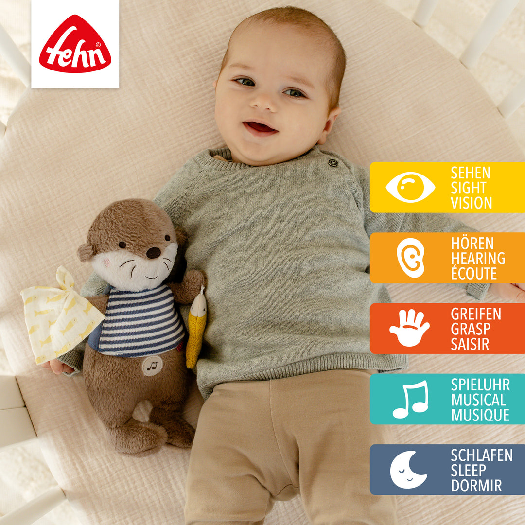 Baby liegt mit Baby Einschlafhilfe Otter im Babybett
