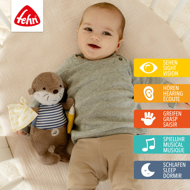 Baby liegt mit Baby Einschlafhilfe Otter im Babybett

