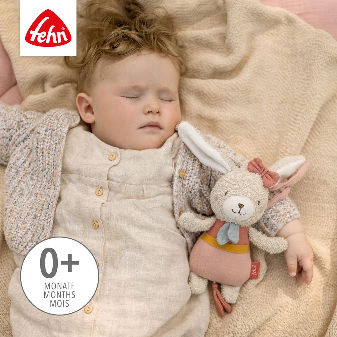 Baby schläft mit Baby Spieluhr Hase im Arm