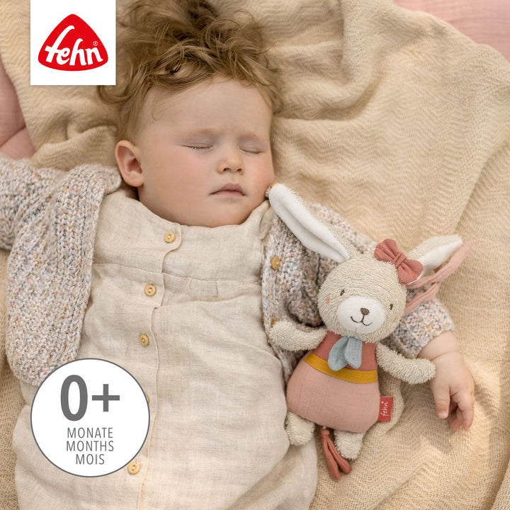 Baby schläft mit Baby Spieluhr Hase im Arm
