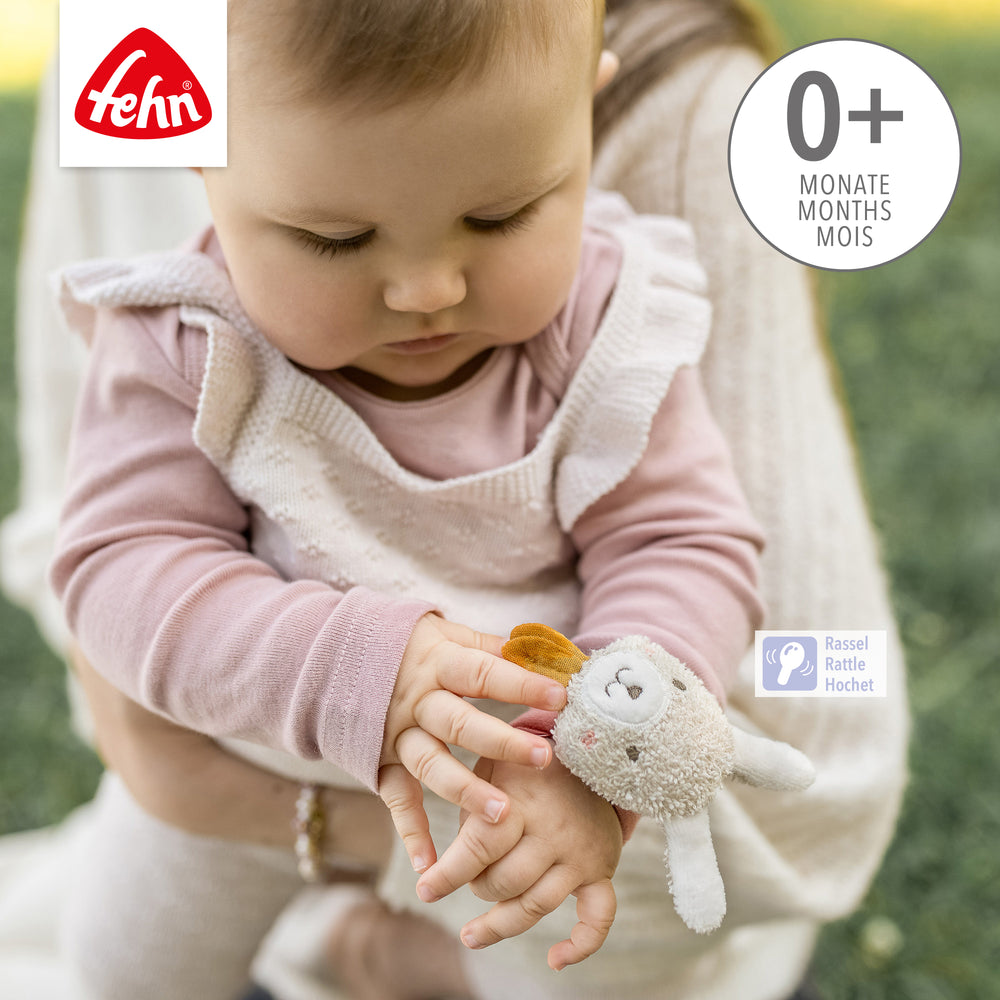 Baby trägt Baby Rasselarmband Hase am Handgelenk