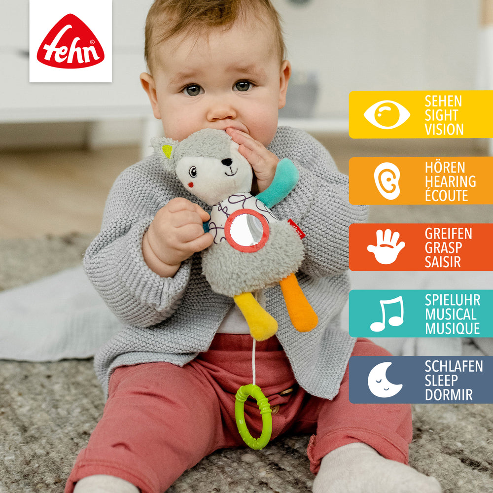 Baby spielt sitzend mit Baby Spieluhr Fuchs