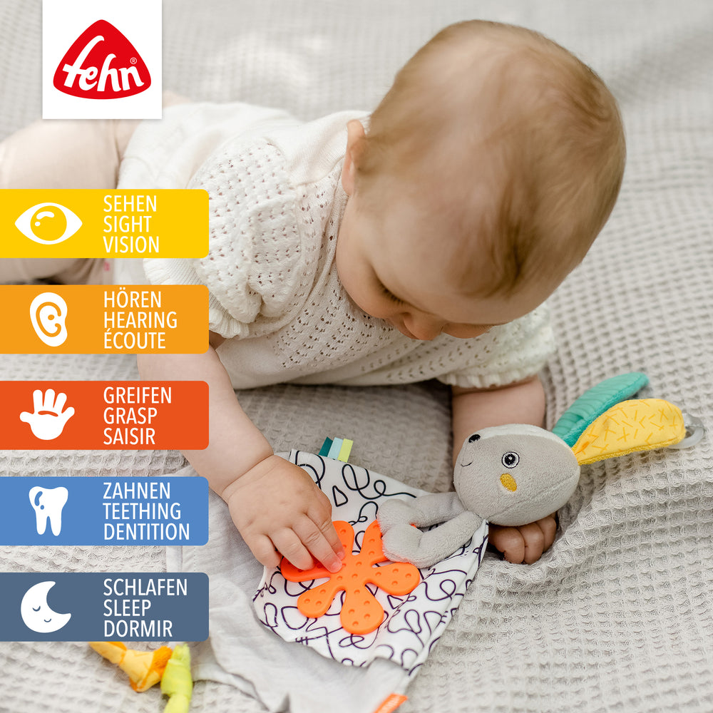 Baby spielt mit Activity-Schmusetuch Hase