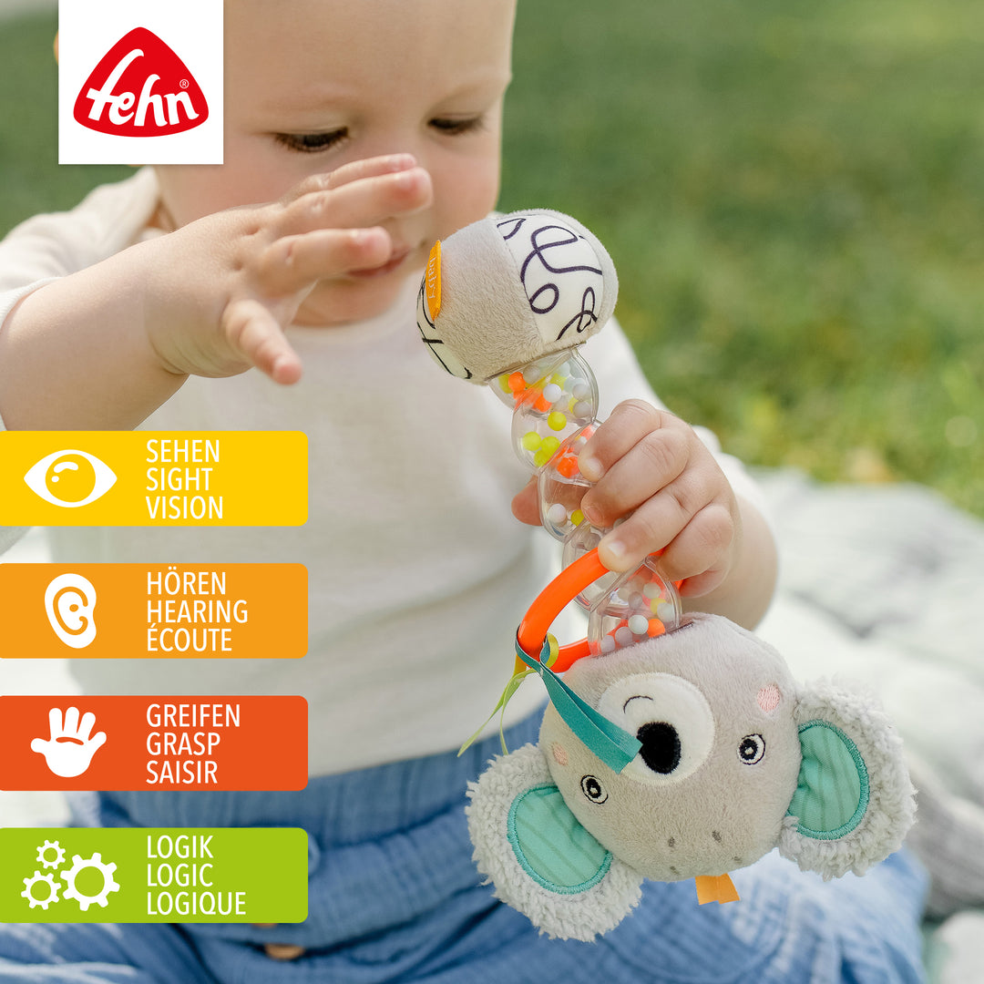 Baby spielt mit Plüsch-Regenmacher Koala