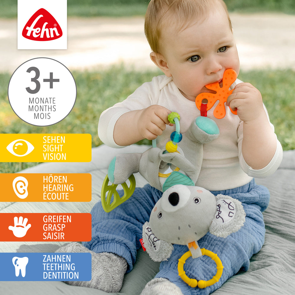 Baby spielt mit Baby Activity-Koala aus weichem Plüsch