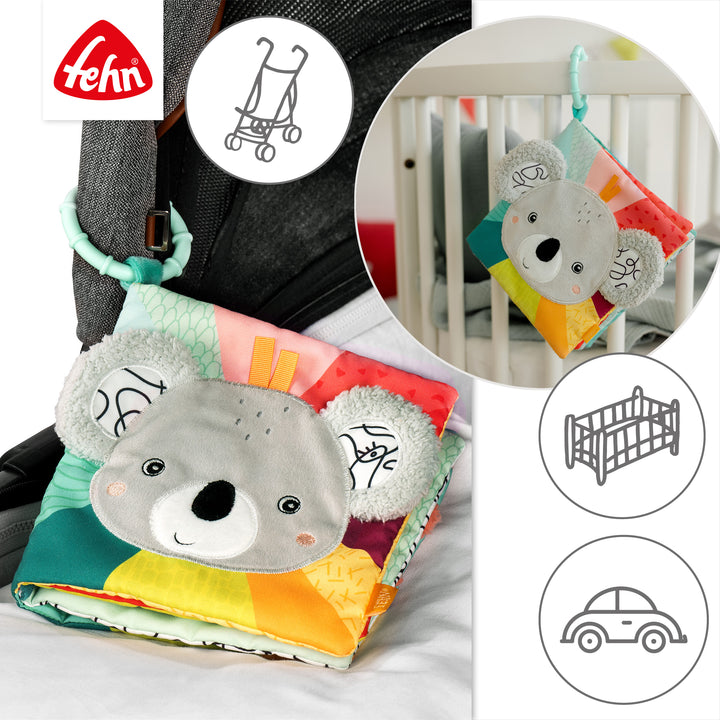 Baby Stoffbuch Koala an Kinderwagen und Babybett befestigt