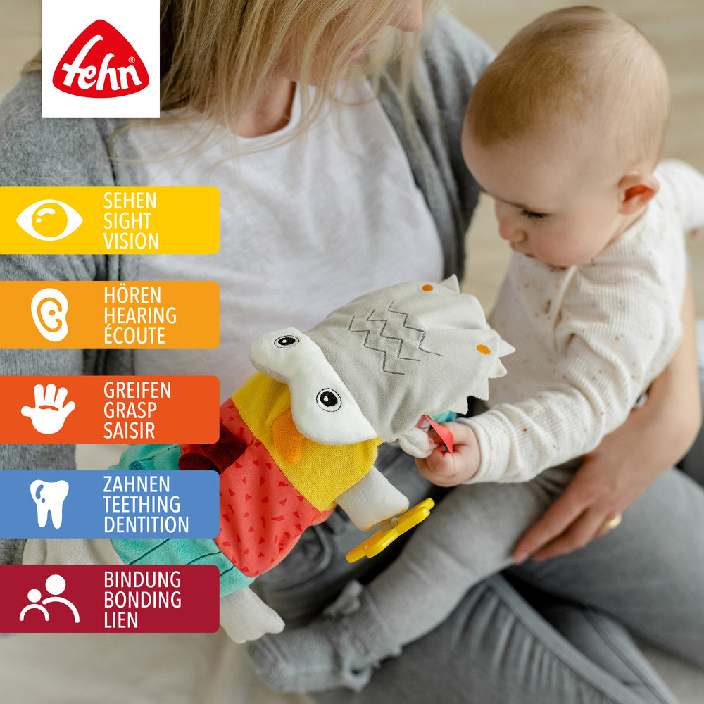 Baby greift nach Baby Handpuppe Krokodil aus weichem Plüsch