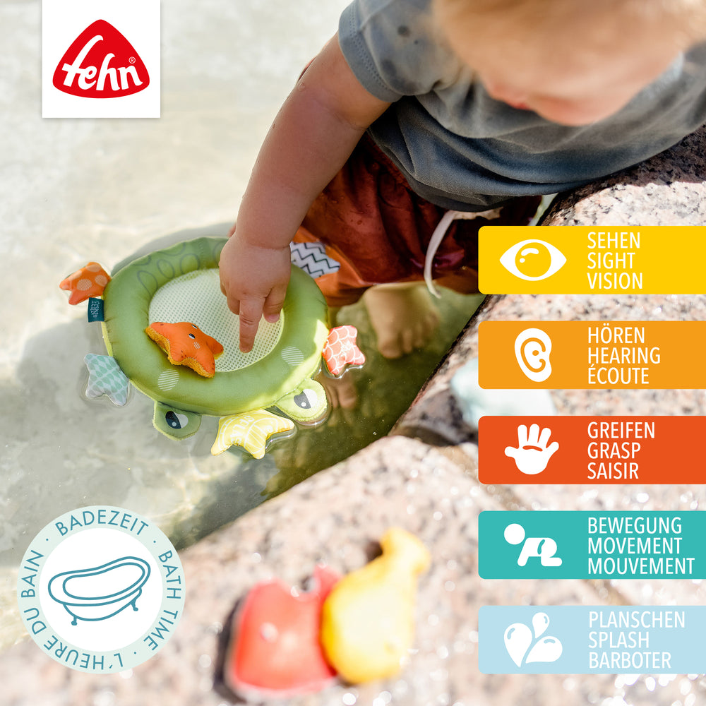 Baby spielt draußen mit Baby Badekescher Frosch