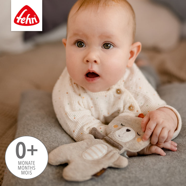Baby spielt mit Baby Knister-Teddy