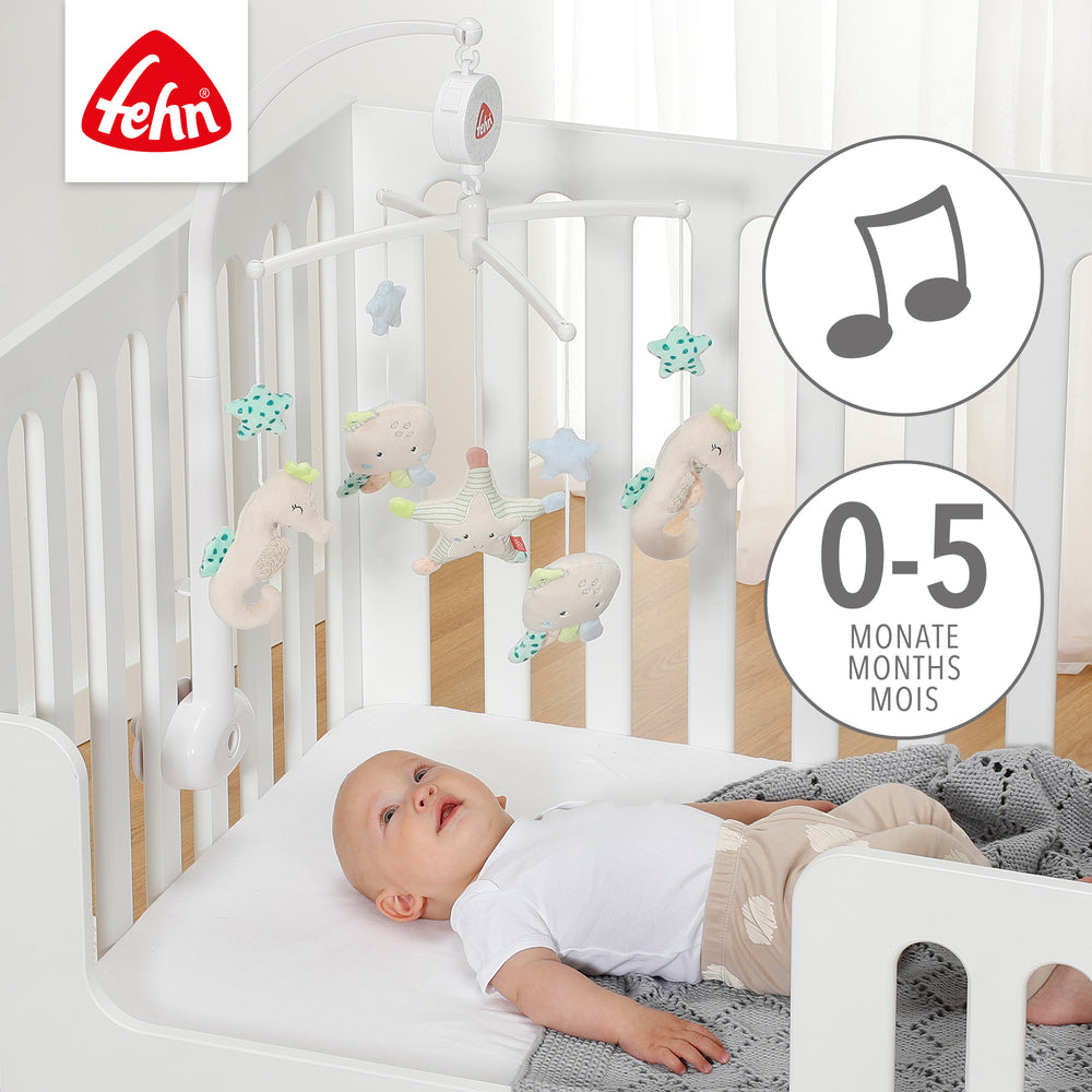Baby liegt unter Baby Musik-Mobile Meereskinder