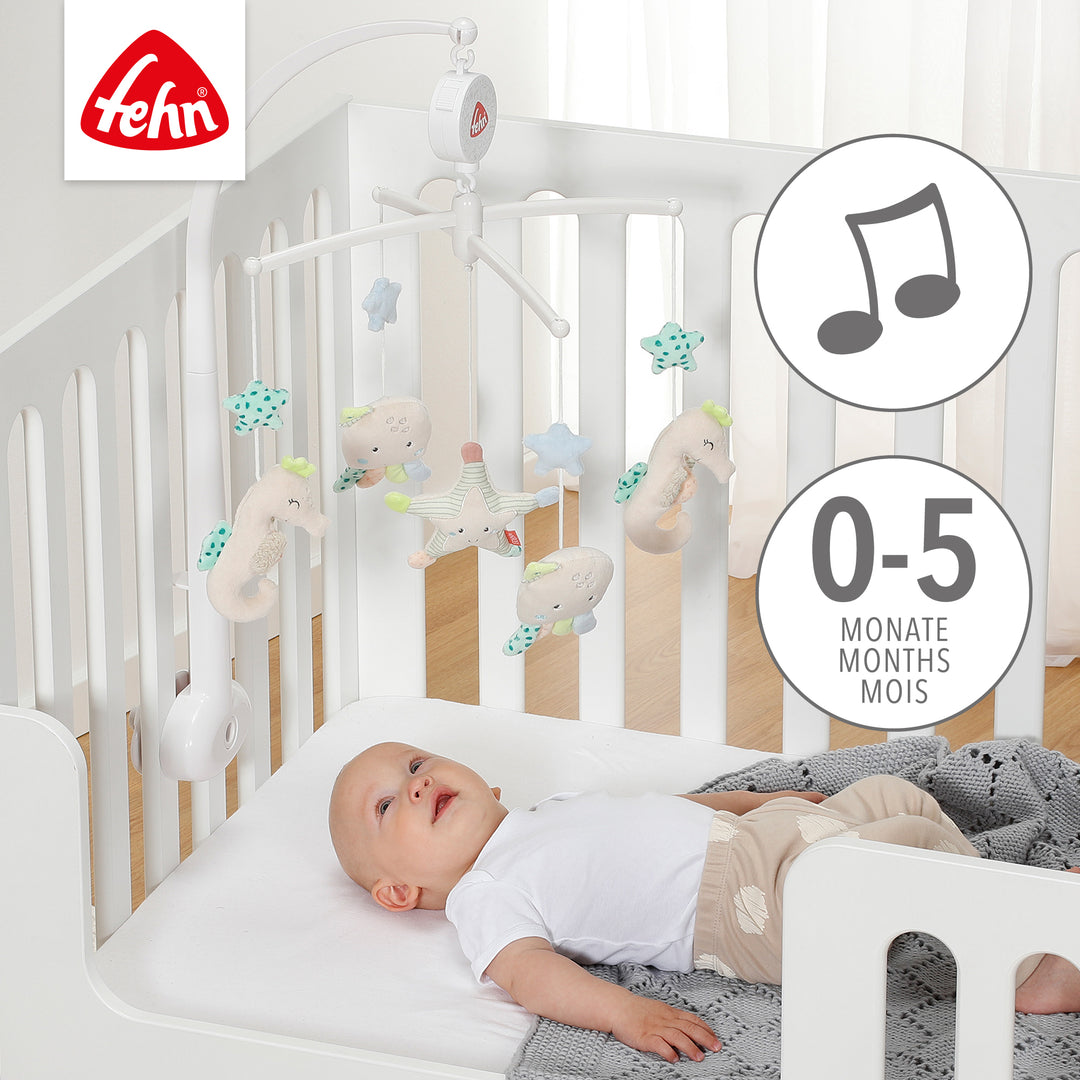 Baby liegt unter Baby Musik-Mobile Meereskinder