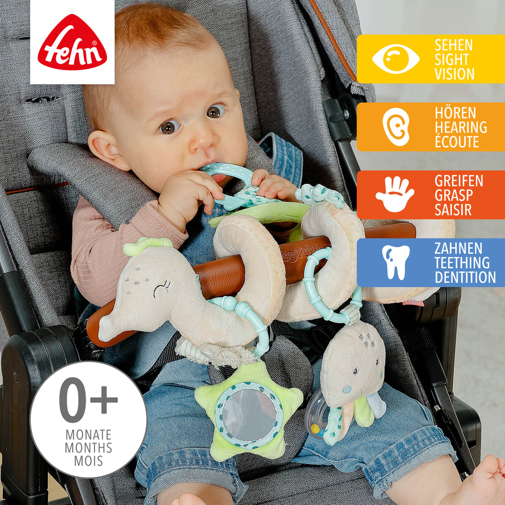 Baby spielt mit Baby Activity-Spirale Seepferd aus weichem Plüsch