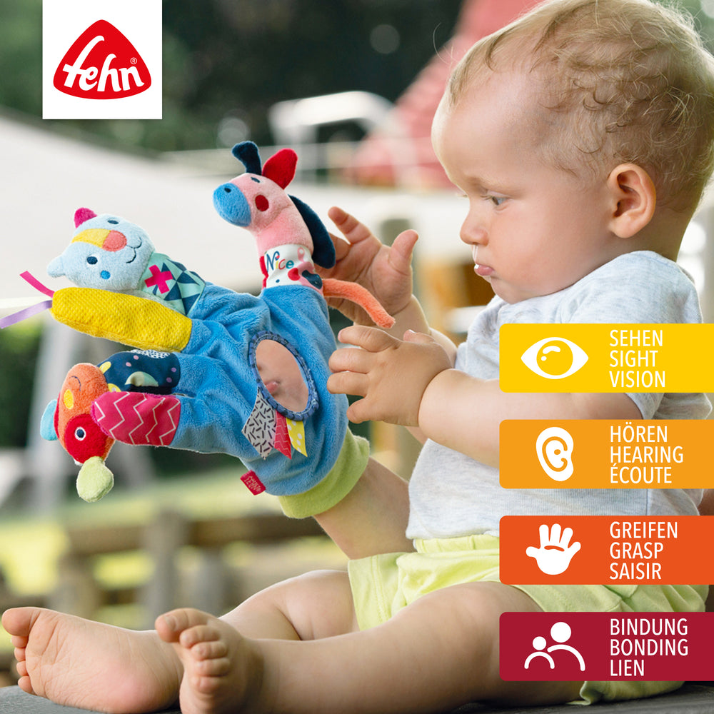 Baby greift nach Baby Spielhandschuh COLOR Friends aus weichem Plüsch