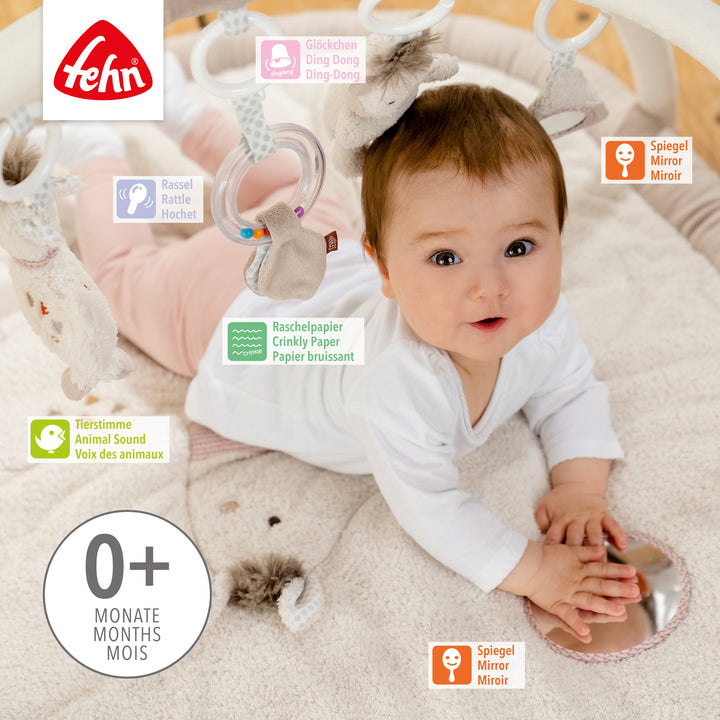 Baby liegt in Baby 3-D-Activity-Decke Peru und spielt mit Spielelement