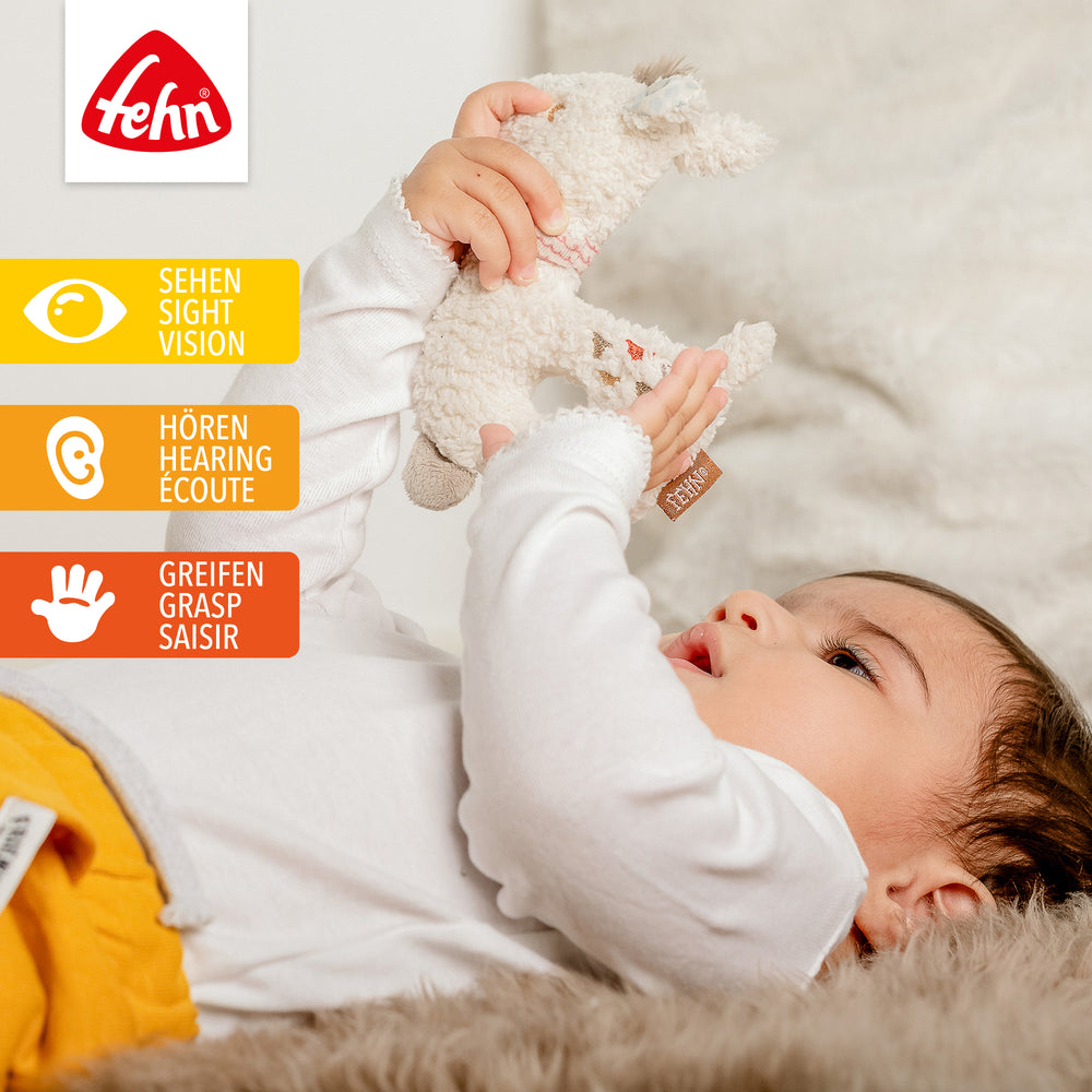 Baby hält Plüsch-Ring-Greifling Lama
