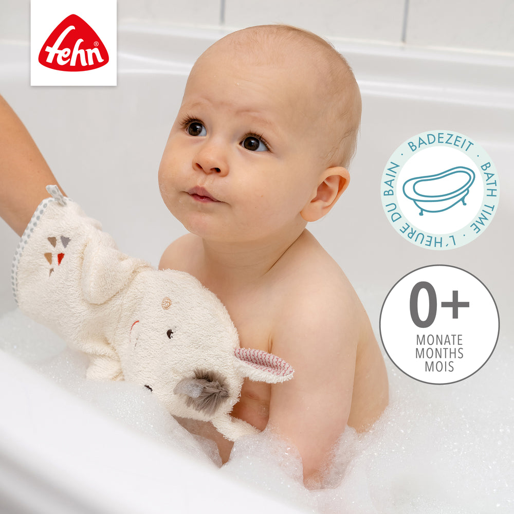 Baby mit Baby Wachhandschuh Lama in der Badewanne