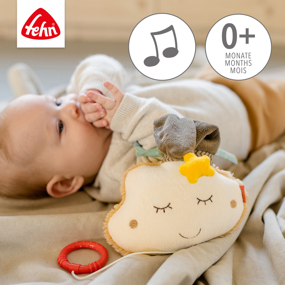 Baby spielt liegend mit Baby Spieluhr Wolke
