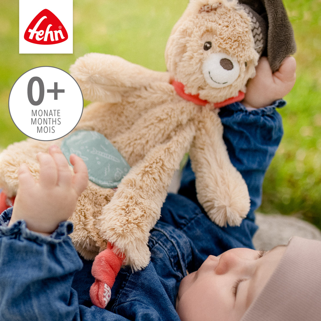Baby spielt mit  Baby Schmusetuch Bär