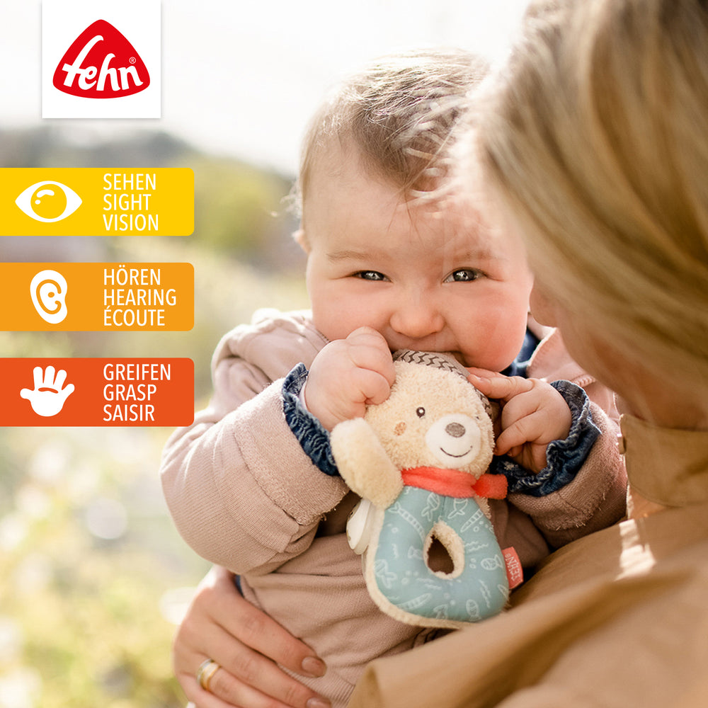 Baby spielt mit Plüsch-Ring-Greifling Bär