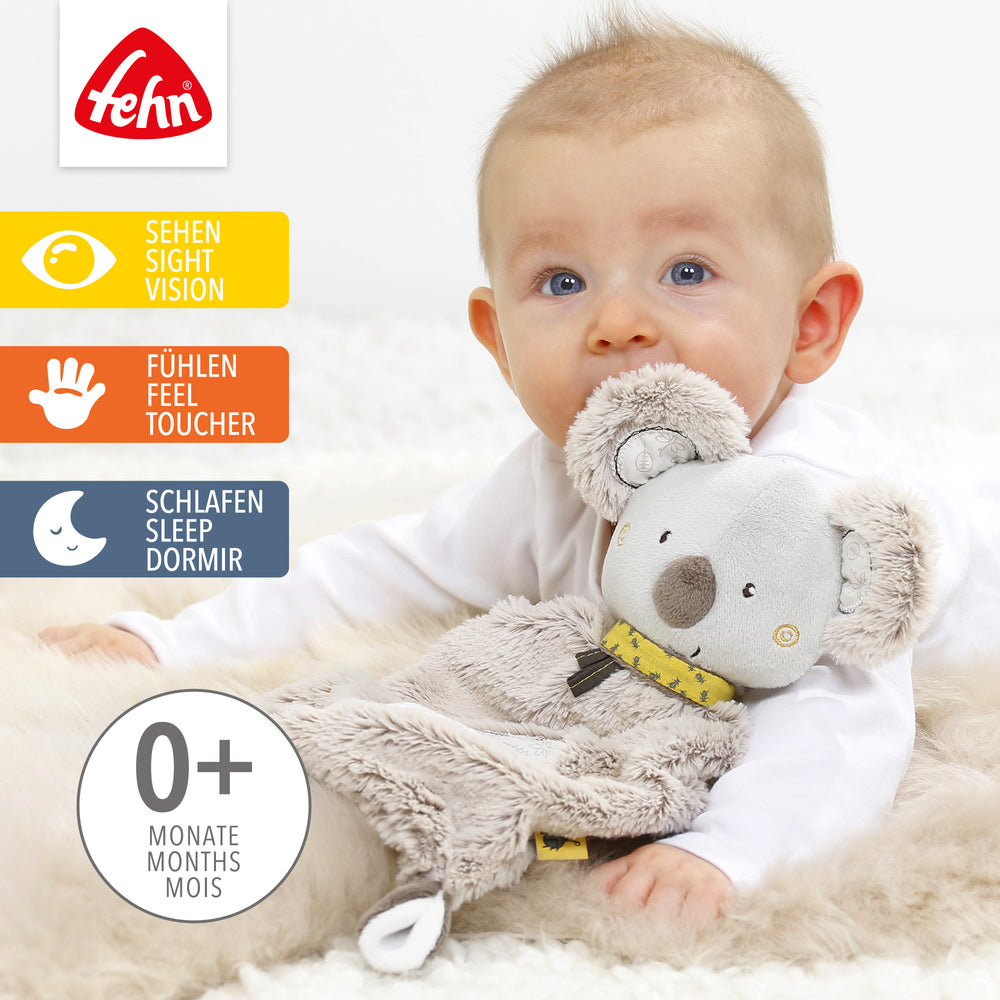 Baby kuschelt mit  Plüsch-Schmusetuch Koala