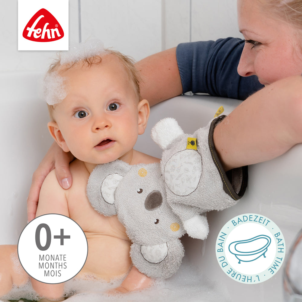 Baby mit Baby Wachhandschuh Koala in der Badewanne
