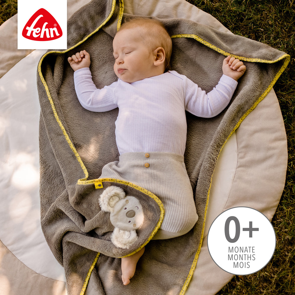 Baby liegt in Baby Kuscheldecke Koala