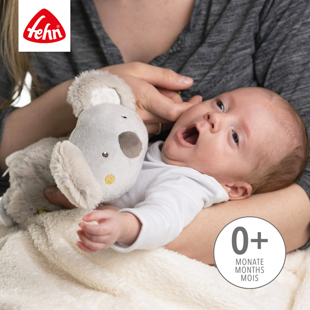Baby kuschelt mit Baby Wärmetier Koala aus weichem Plüsch