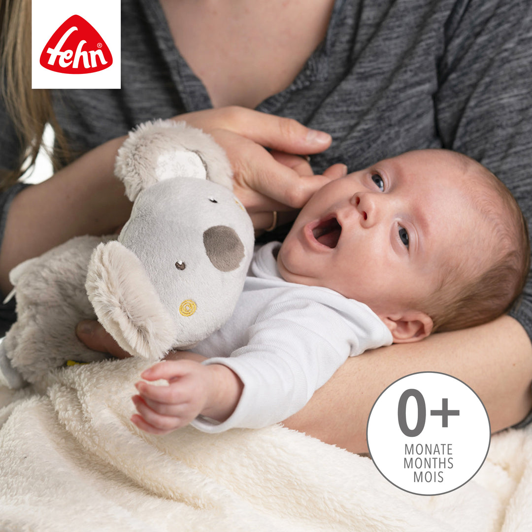 Baby kuschelt mit Baby Wärmetier Koala aus weichem Plüsch