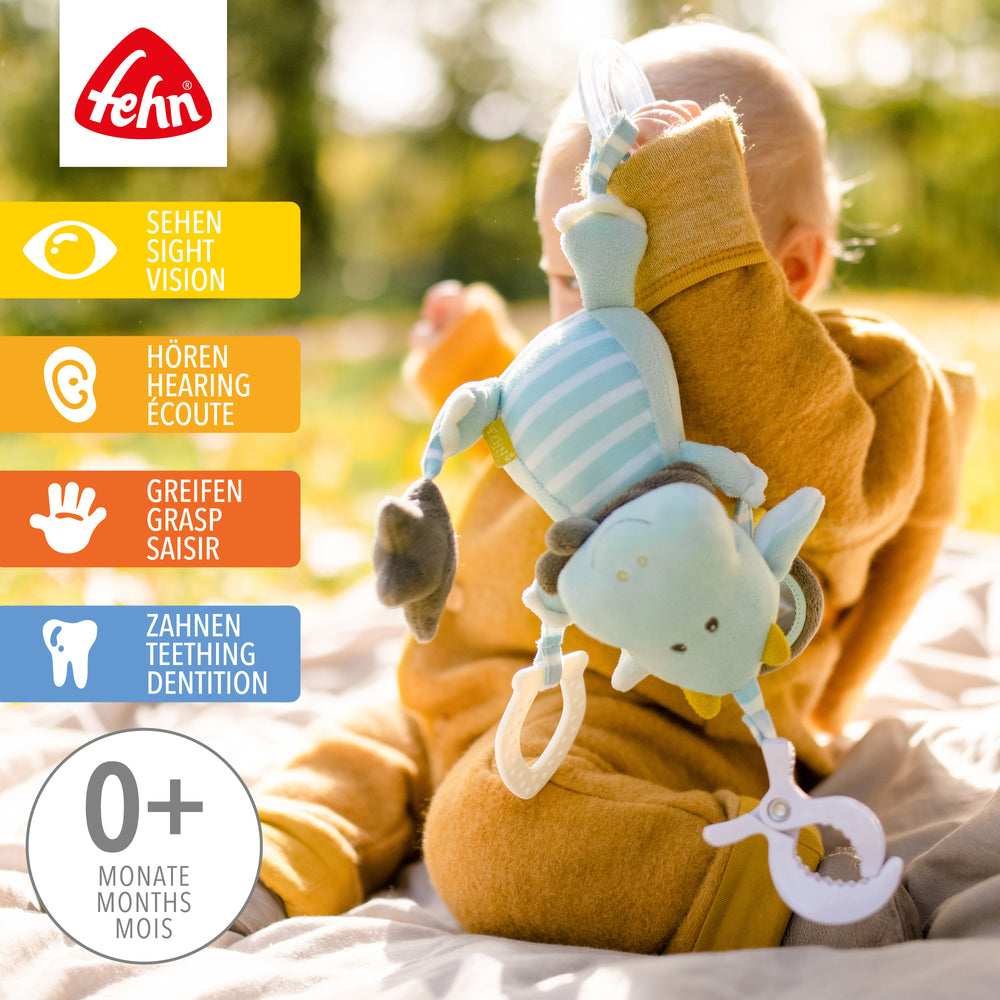 Baby spielt mit Baby Activity-Drache aus weichem Plüsch