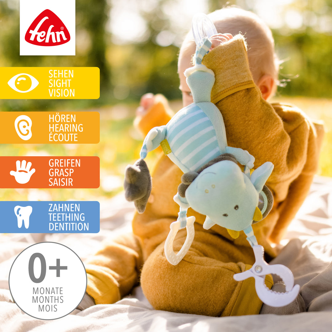 Baby spielt mit Baby Activity-Drache aus weichem Plüsch