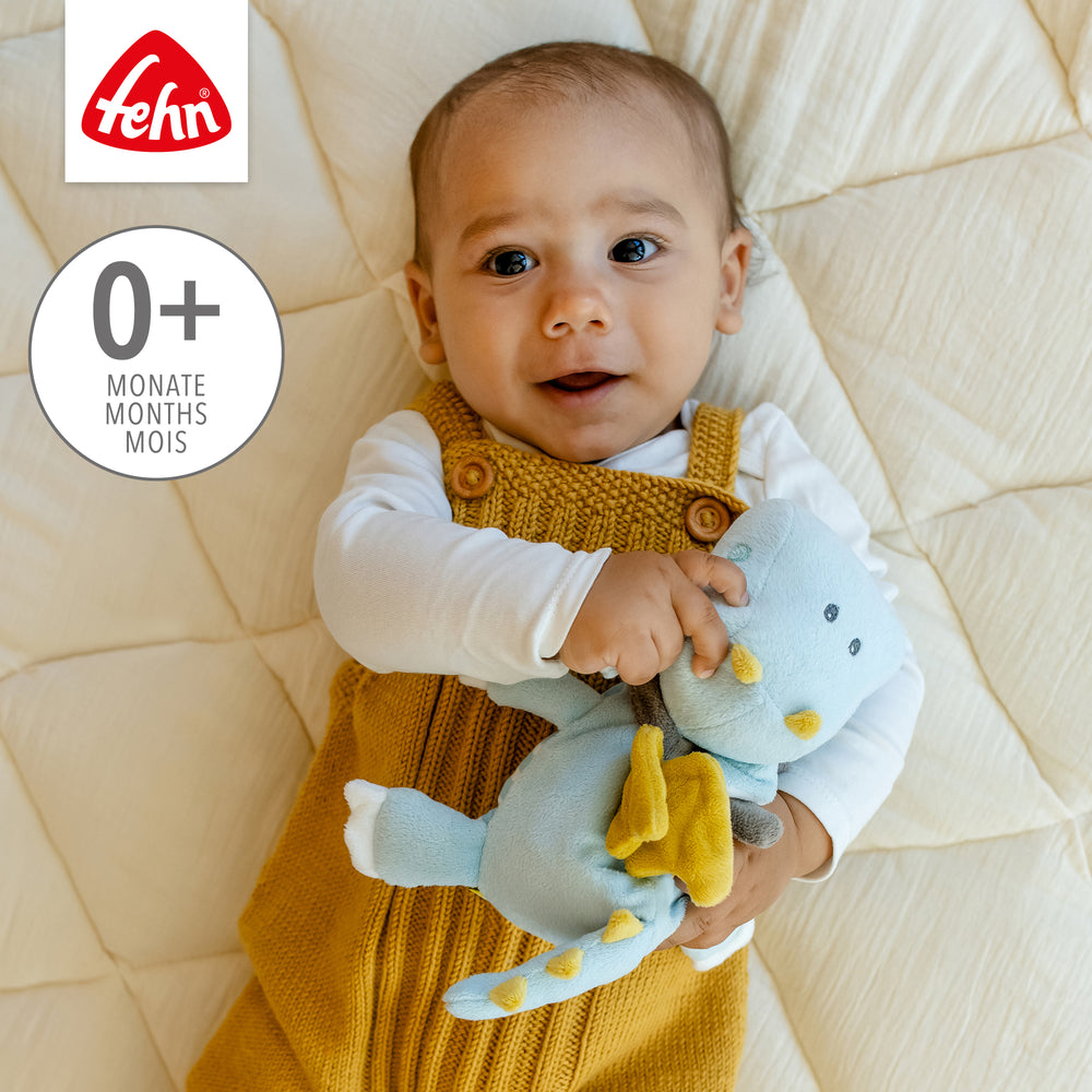 Baby kuschelt mit Baby Wärmetier Drache aus weichem Plüsch