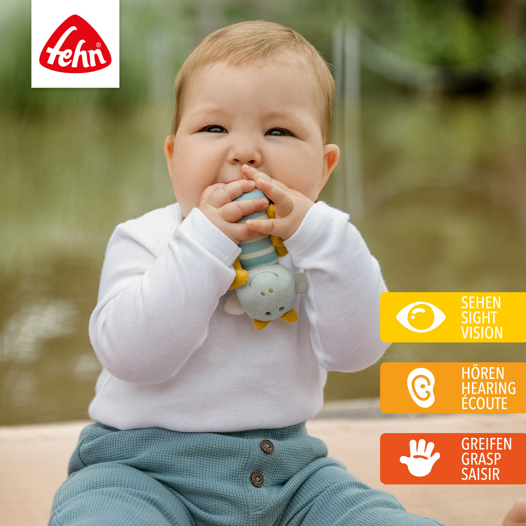 Baby spielt mit Plüsch-Mini-Rassel Drache