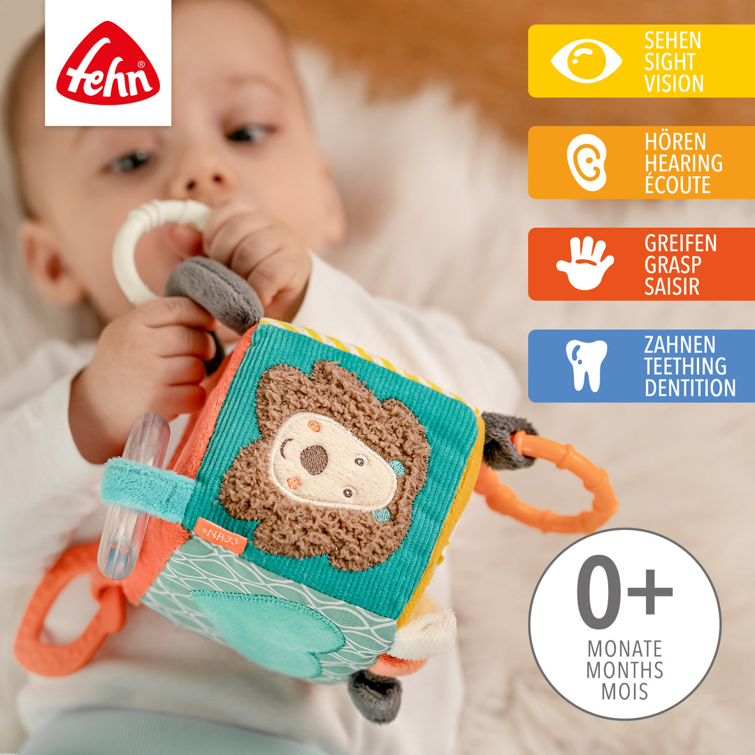 Baby spielt mit Baby Activity-Würfel Funky Friends aus weichem Plüsch