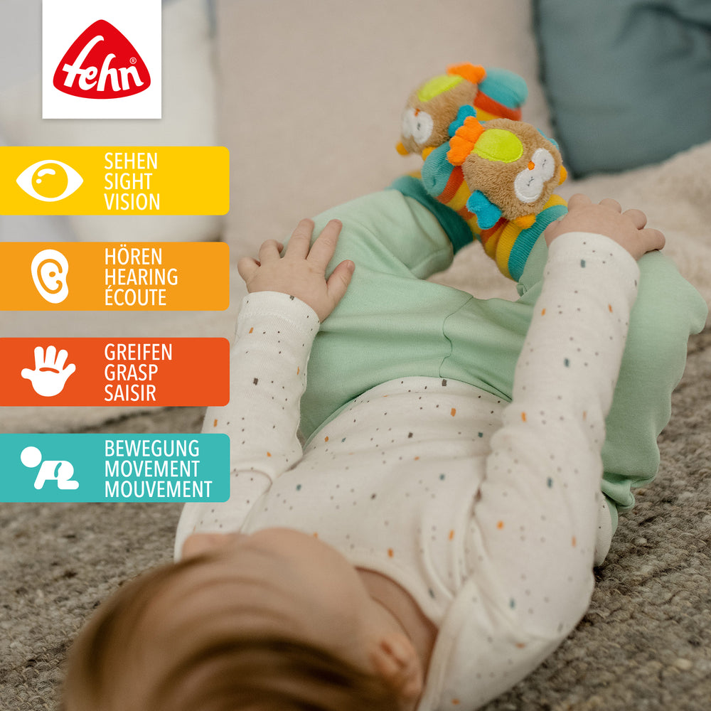 Baby trägt Baby Rasselsocken Eule an den Füßen